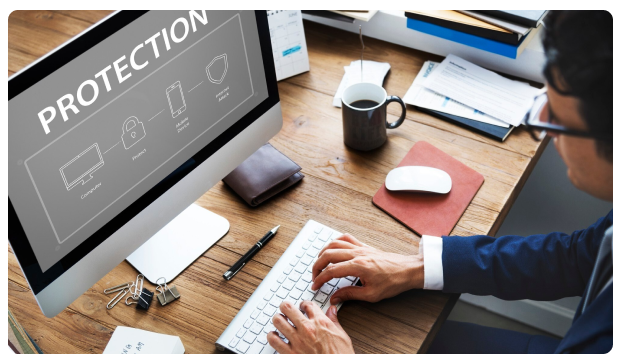Computer monitor displaying the word 'Protection' with security icons on a desk